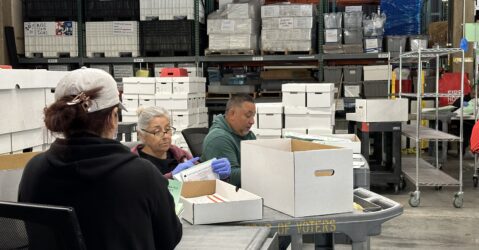 Election workers look through boxes of ballots at the Santa Clara County Registrar of Voters during a recount effort