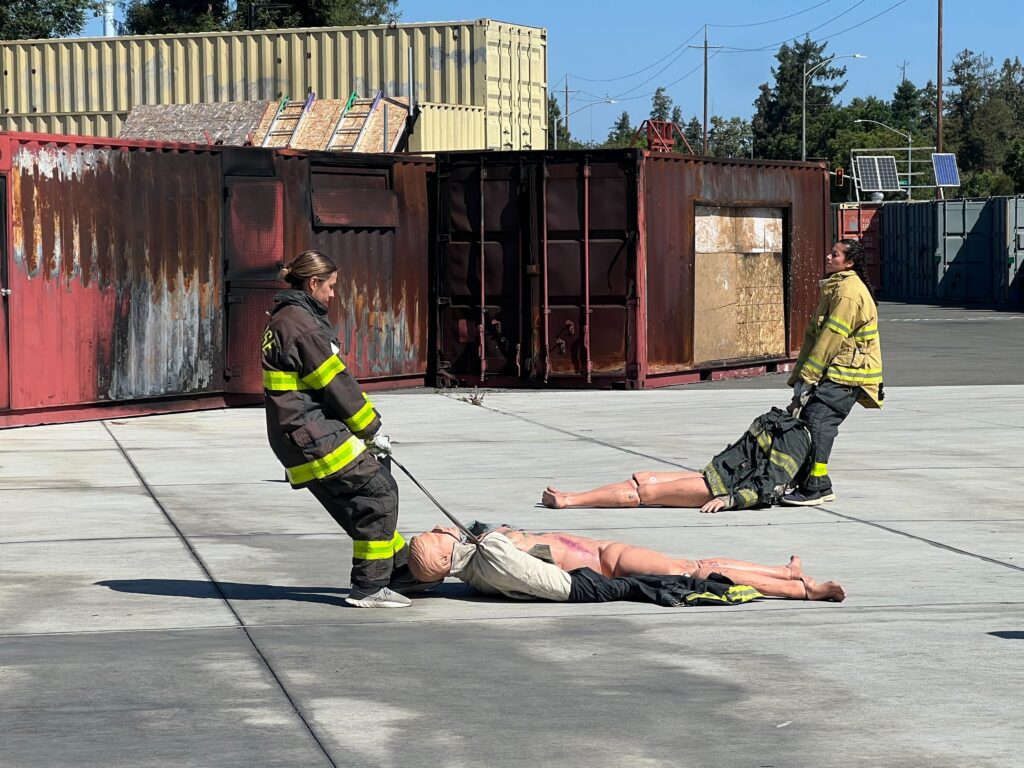 Two women in firefighter gear during a training exercise in San Jose, California