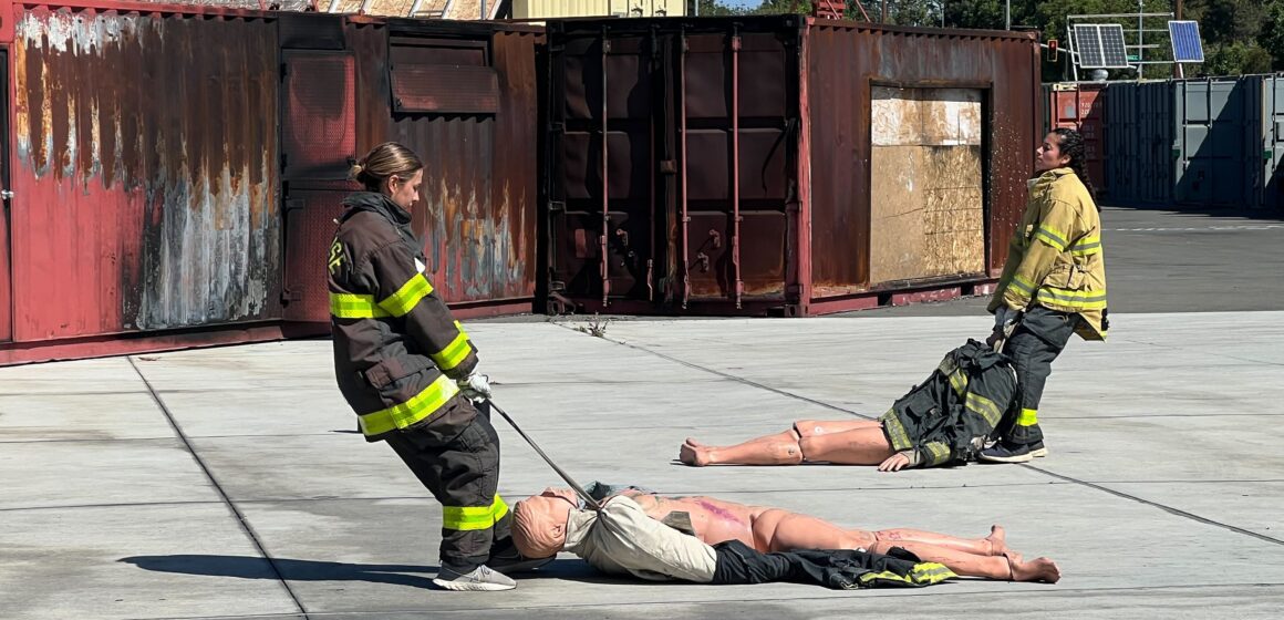 Two women in firefighter gear during a training exercise in San Jose, California