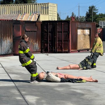 Dos mujeres con uniforme de bombero durante un ejercicio de entrenamiento en San José, California.