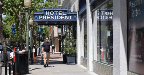 A person walking under the awning of a hotel in Palo Alto, California