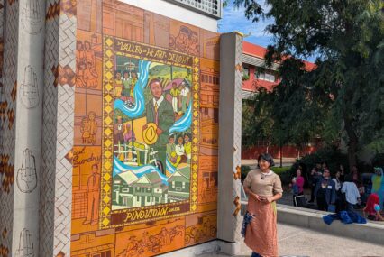 A woman standing next to a mural on a college campus in San Jose, California